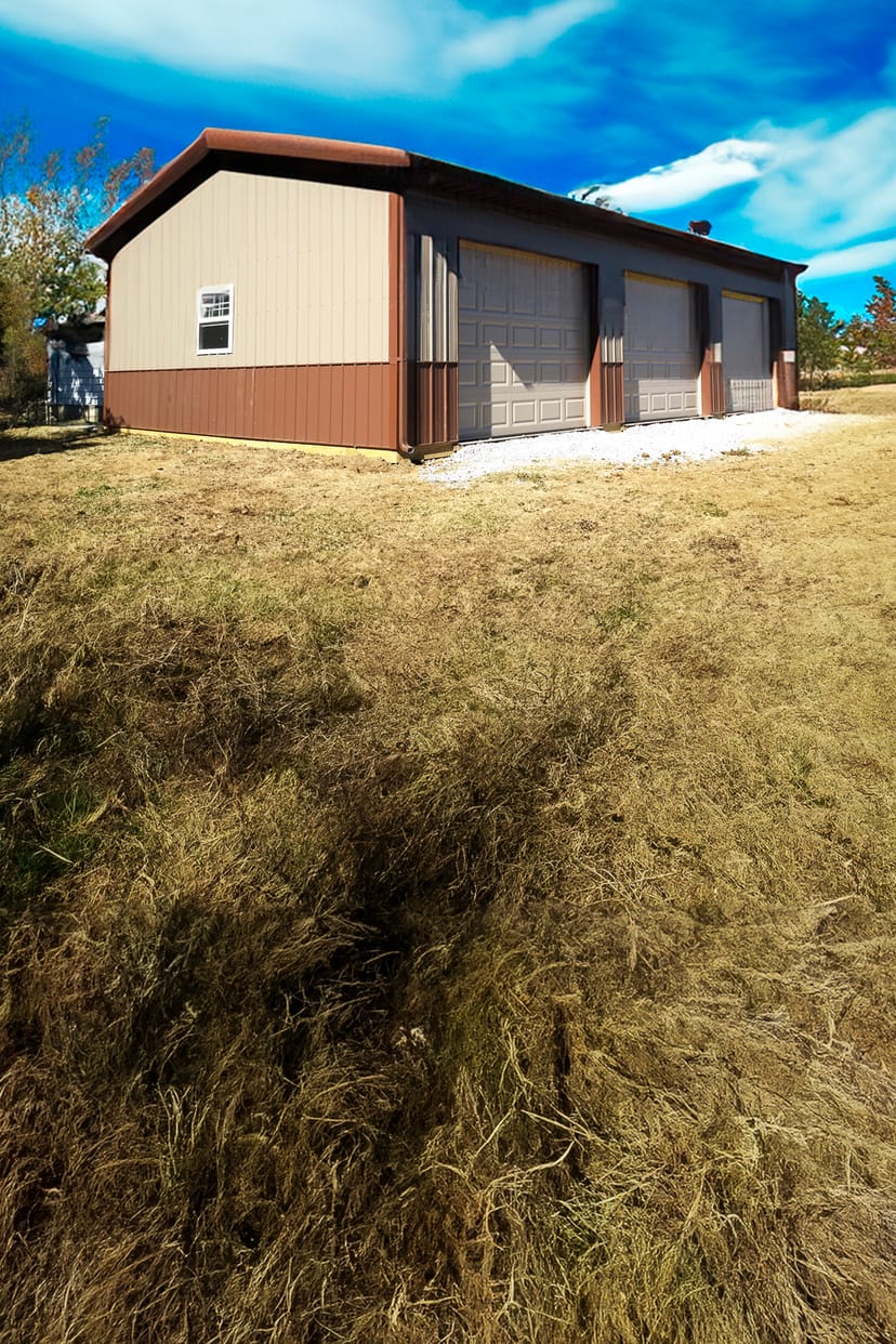 The image shows a post-frame building by Built-Mor Buildings, featuring a gable roof and smooth metal siding in two tones, with a brown lower section and beige upper section. The structure includes three large garage doors and one small window on the visi